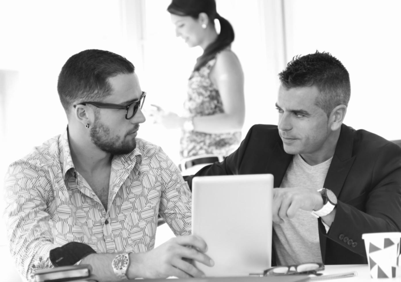 Professional collaboration workspace with financial advisors reviewing investment automation strategies